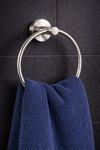 Handtuchring aus Metall an einer Fliesenwand mit einem Handtuch.