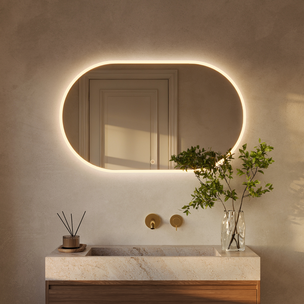 Ovaler Badezimmerspiegel mit integrierter LED Beleuchtung und Touch Schalter über einem Steinwaschbecken mit Holzunterschrank und Armatur.