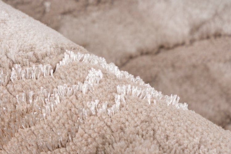 Detailansicht eines Teppichs mit Hoch-Tief-Struktur und weichem Flor.