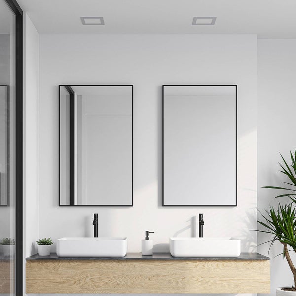 Helles, modernes Badezimmer mit zwei rechteckigen Spiegeln in schwarzen Rahmen über zwei weißen Aufsatzwaschbecken auf einem Holzwaschtisch.