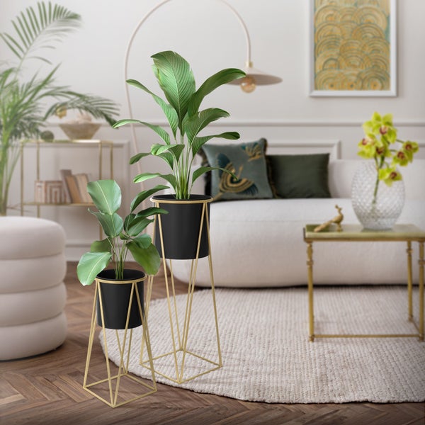 Zwei Pflanzenständer mit Töpfen im Wohnzimmer, moderne Metallgestelle mit Pflanzgefäßen in einem eleganten Interieur.