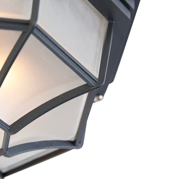 Detail einer Außenleuchte mit schwarzem Metallrahmen und mattiertem Glas in geometrischer Form.