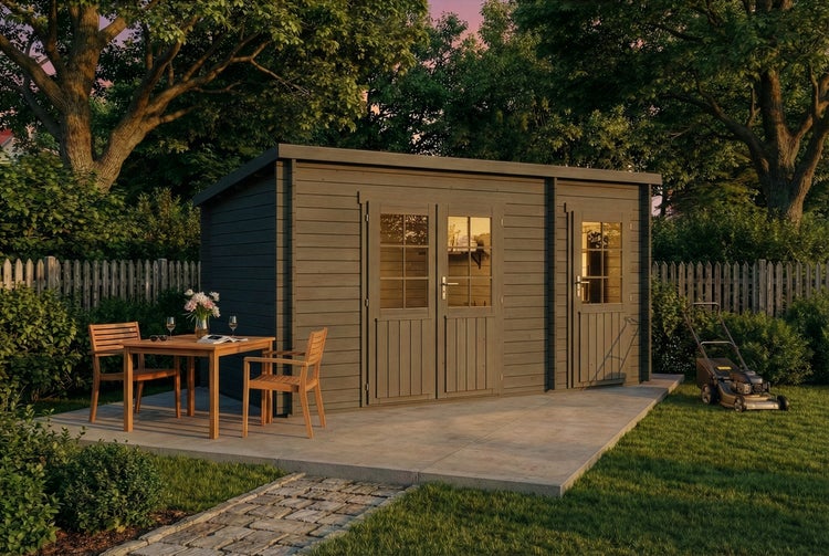 Graues Gartenhaus aus Holz mit Doppeltür und Einzeltür auf einer Steinterrasse in einem grünen Garten mit Sitzgruppe und Rasenmäher.