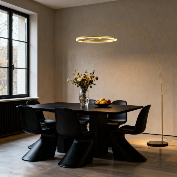 Modernes Esszimmer mit schwarzem Tisch, S-förmigen Stühlen und einer goldfarbenen LED-Bogenstehleuchte über dem Tisch.