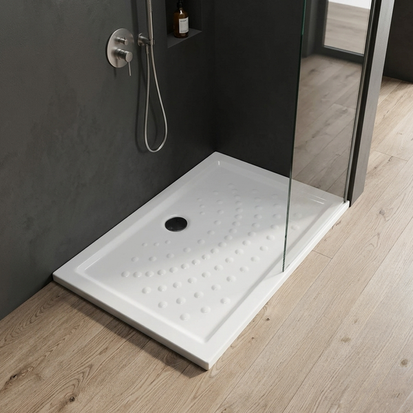 Rechteckige Duschwanne mit genoppter Oberfläche und rundem Ablauf in einem modernen, dunklen Badezimmer mit Holzboden und Glaswand.