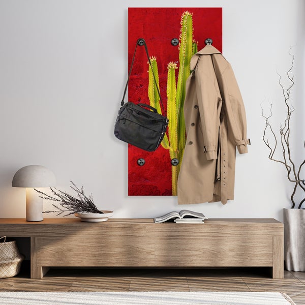 Wandgarderobe mit Kaktusmotiv, Mantel und Tasche in einem modern eingerichteten Raum