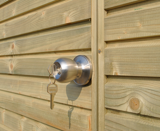 Runder Türknauf aus Edelstahl mit eingestecktem Schlüssel an einer Holztür eines Gartenhauses.