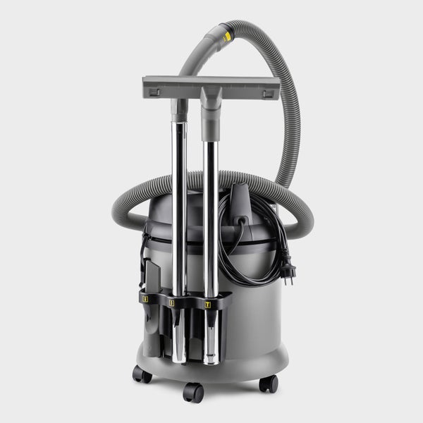 Grauer Nass-Trockensauger mit Zubehöraufbewahrung, Saugschlauch und Saugrohren aus Metall auf Rollen.