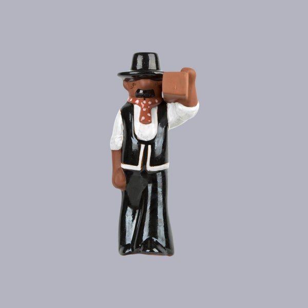 Dekofigur eines Handwerkers in Zunftkleidung mit einem Backstein auf der Schulter.