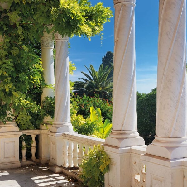 Szene mit Marmorsäulen und üppigem Grün, die eine elegante Außenarchitektur zeigen
