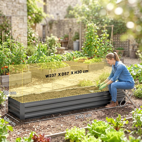 Rechteckiges Hochbeet aus verzinktem Stahl in einem organisierten Garten mit Tomatenpflanzen und Blattgemüse auf dunkler Erde.