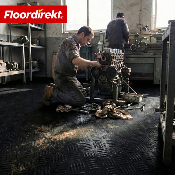 Werkstatt mit Bodenbelag mit Riffelblechmuster und Mechaniker bei der Arbeit