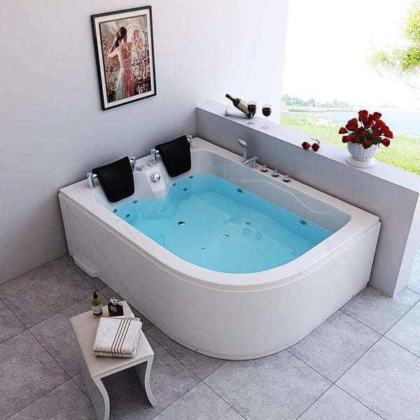 Moderne Eckwhirlwanne mit zwei Nackenkissen und Massagejetdüsen in einem eleganten Badezimmer mit Fliesenboden und Ausblick ins Grüne.