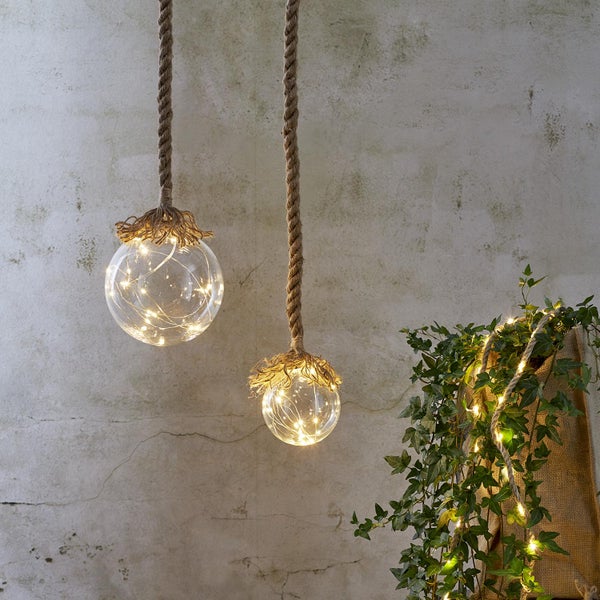 Zwei Hängelampen mit Seilaufhängung und Kugelschirm gefüllt mit Lichtern