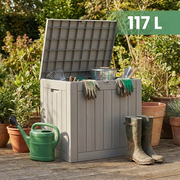 Offene Gartenbox aus Kunststoff in Holzoptik mit 117 Liter Volumen, mit Werkzeug, Gießkanne und Stiefeln auf einer hellen Terrasse mit Pflanzen.