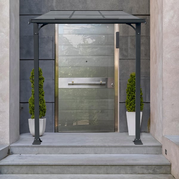 Moderne Haustürüberdachung aus Aluminium mit Glasdach und zwei Stützen vor einer grauen Hauseingangstür.