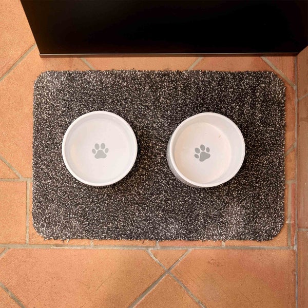 Zwei Futternäpfe mit Pfotenabdruck auf einer Schmutzfangmatte