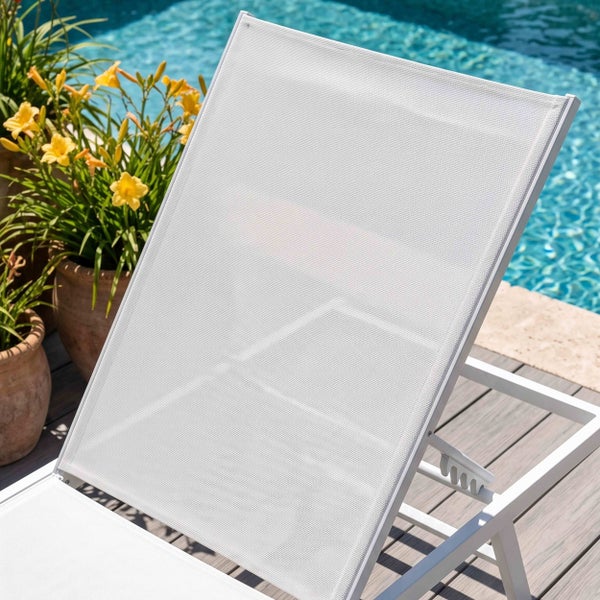 Weiße Gartenliege aus Aluminium und Textilene an einem Pool auf einer Holzterrasse neben gelben Blumen in Terrakottatöpfen.