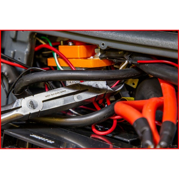 Detailaufnahme eines Werkzeugs zwischen elektronischen Bauteilen und Kabeln.