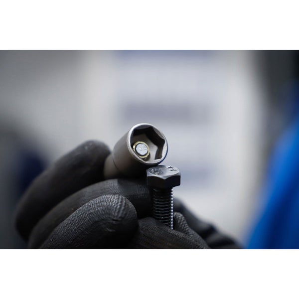 Eine Hand in Arbeitshandschuhen hält eine Stecknuss und eine Schraube.