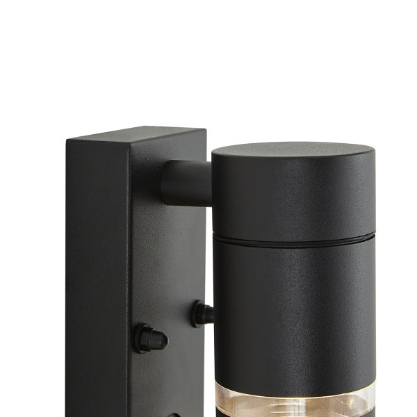 Schwarze Außenwandleuchte mit zylindrischem Kopf und rechteckiger Wandhalterung aus Metall.