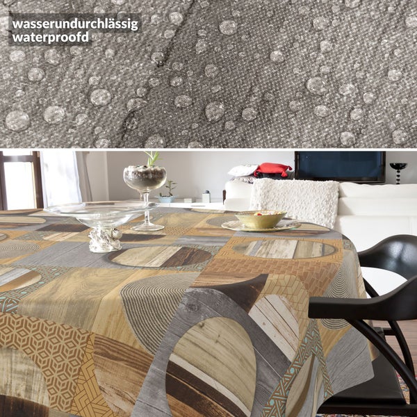 Wasserdichte Tischdecke mit Patchwork-Muster aus Holzoptik und geometrischen Formen; Nahaufnahme zeigt Wassertropfen auf der Oberfläche.