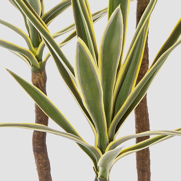 Künstliche Monstera Pflanze mit großen grünen Blättern, Kokosstab und Luftwurzeln in einem schwarzen Topf.