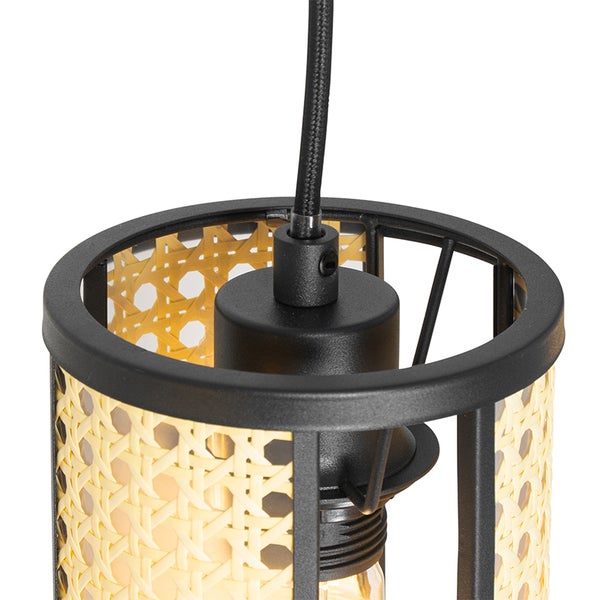 Detailaufnahme einer Hängeleuchte mit Rattanschirm und schwarzer Aufhängung