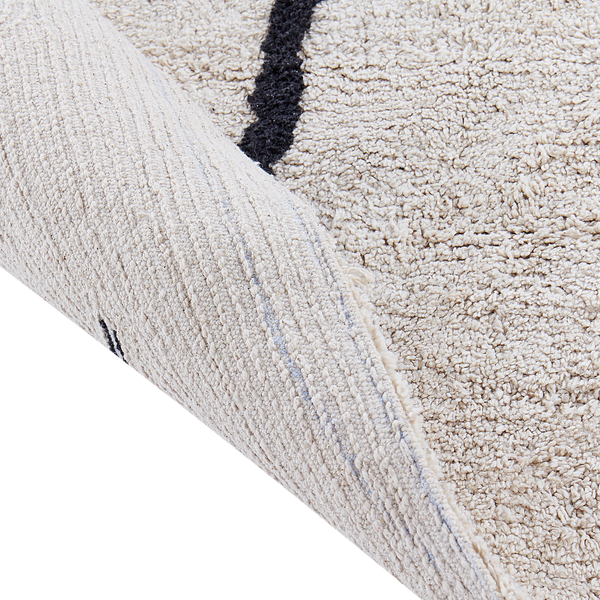 Nahaufnahme eines Hochflor-Teppichs mit sichtbarer gewebter Rückseite und weicher Struktur.