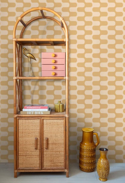 Vliestapete mit geometrischem Wellenmuster im Retro-Stil in einem Wohnraum mit Bambusregal und Keramikvasen.