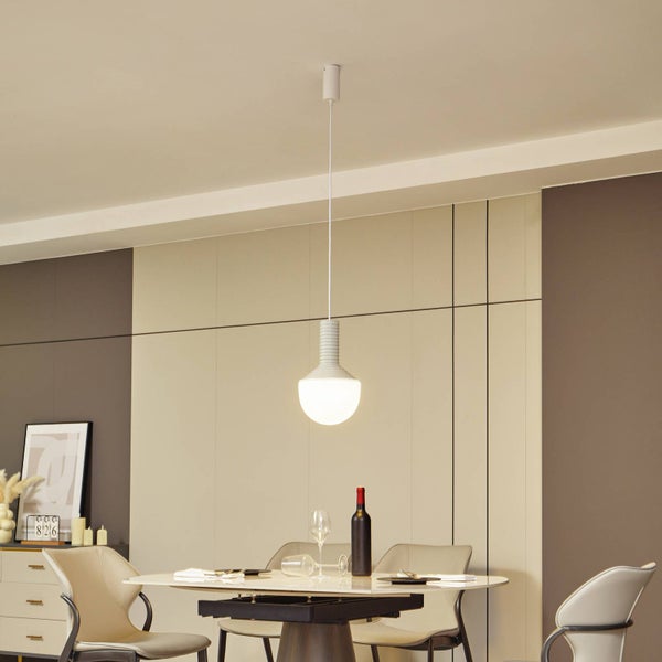 Moderne weiße Pendelleuchte mit geriffeltem Design über einem gedeckten Esstisch in einem hellen und stilvoll eingerichteten Esszimmer.