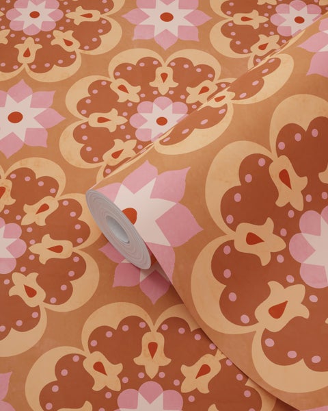 Vliestapete mit Retro-Muster aus stilisierten Blumen und Mandalas in Orange und Rosa.