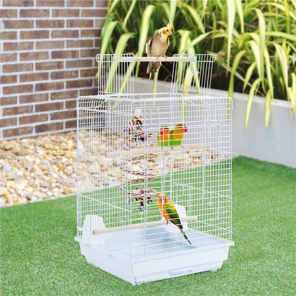 Weißer Vogelkäfig mit mehreren Vögeln und Spielzeug