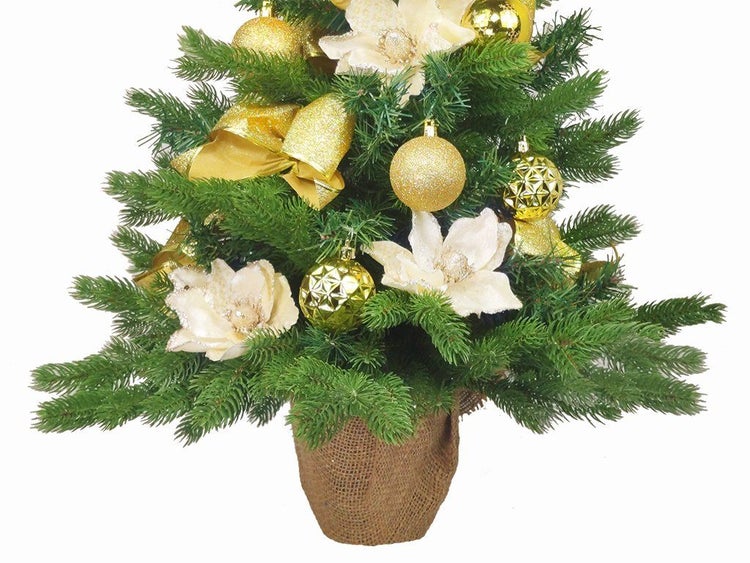 Geschmückter künstlicher Weihnachtsbaum im Jutesack mit Kugeln und Blumen