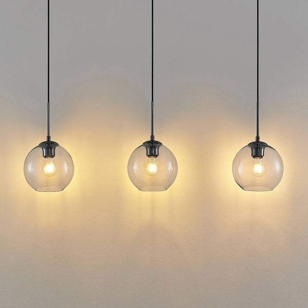 Drei Pendelleuchten mit runden Glasschirmen hängen von der Decke