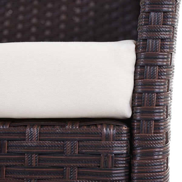 Detailansicht eines braunen Rattansessels mit weißem Sitzkissen.