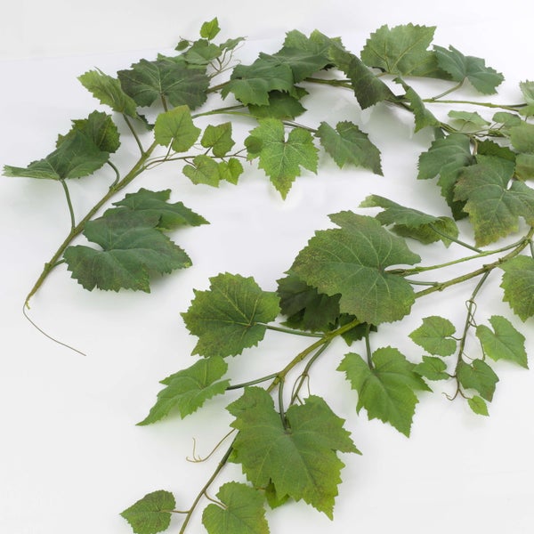 Künstlicher Weihnachtsstern mit roten Blüten und grünen Blättern in einem schwarzen Pflanztopf.