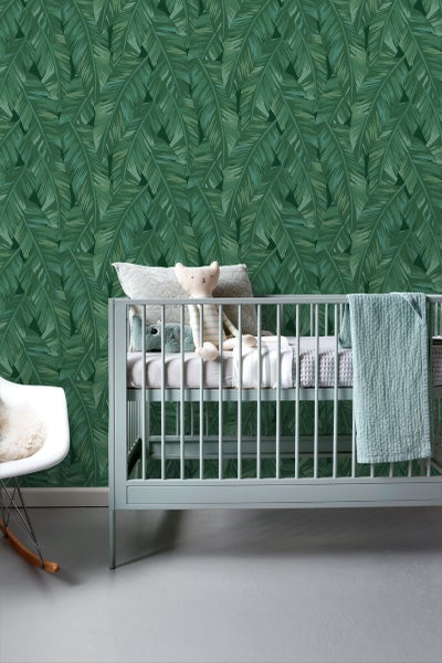 Kinderzimmer mit botanischer Blättertapete, Kinderbett und Schaukelstuhl