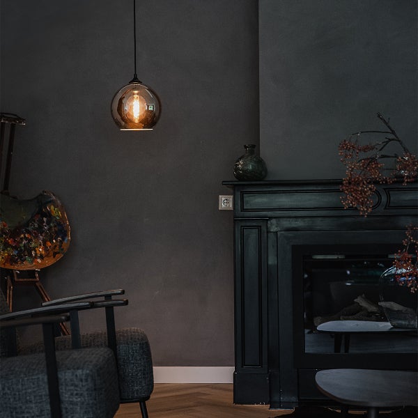 Einrichtungsbeispiel: Wohnzimmer mit Pendelleuchte, Sessel und Kamin