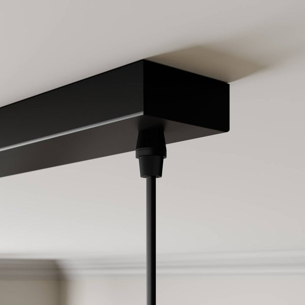 Detailaufnahme einer Deckenleuchte mit schwarzem Baldachin und Kabelaufhängung