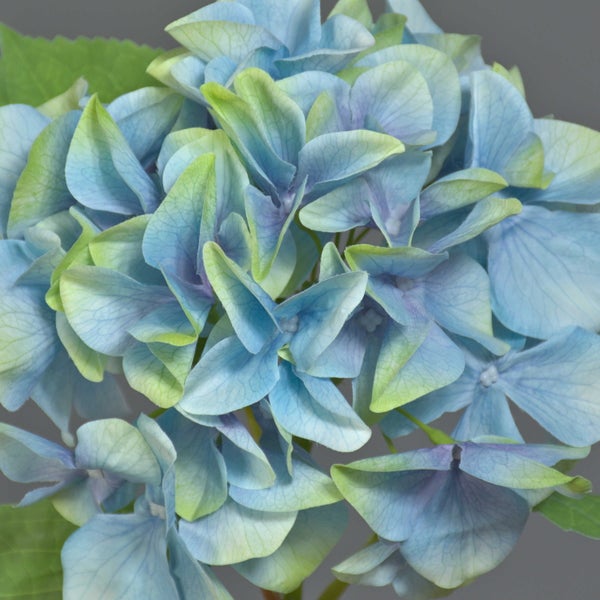 Detailansicht einer künstlichen Hortensie mit fein strukturierten blau-violetten Blütenblättern.