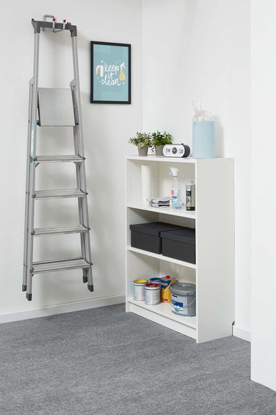 Heller Raum mit an einer Wandhalterung hängender Aluminiumstufenleiter und weißem Regal mit Reinigungsmitteln, Aufbewahrungsboxen und Farbdosen.