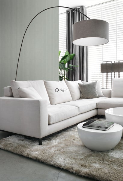 Helle, geräumige Wohnzimmerszene mit Ecksofa, Stehlampe und Beistelltischen