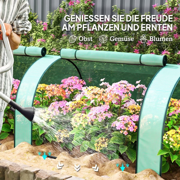 Person gießt ein Gartenbeet mit einem Pflanztunnel, der Pflanzen wie Blumen vor Witterungseinflüssen schützt.