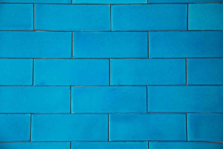 Blaue Wandfliesen im Metro-Stil, rechteckig, glänzend, im versetzten Verband verlegt.
