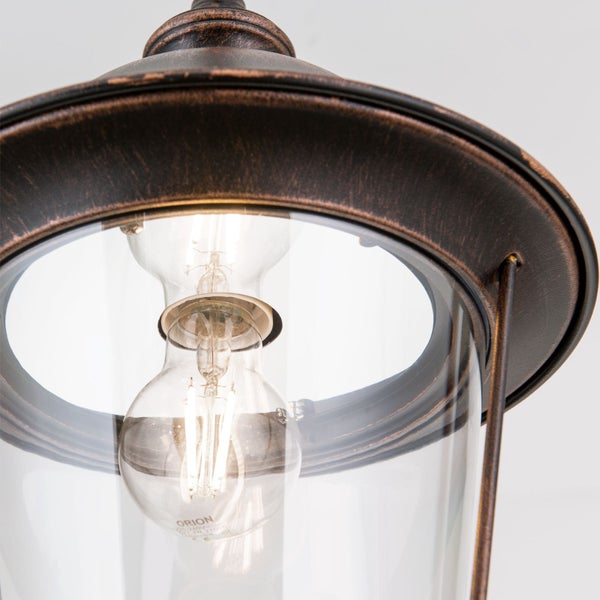 Außenleuchte mit antikem Metallfinish, klarem Glas und sichtbarer Filament-Glühbirne.