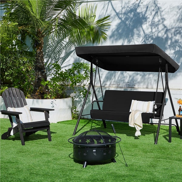 Schwarze Gartenschaukel mit Dach, Adirondack-Stuhl und Feuerschale mit Stern- und Mondmotiven in einem hellen Garten.