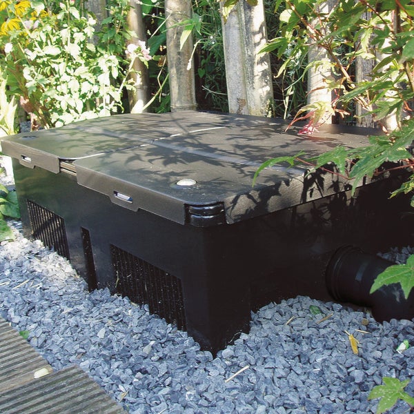 Schwarze Kunststoff-Filterbox für Teichanlagen im Garten auf Kies platziert.