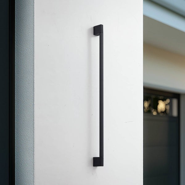 Moderne, minimalistische Außenwandleuchte in Schwarz, vertikal an einer Wand montiert.