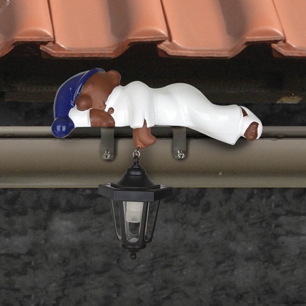 Dachrinnenfigur Schlafwandler mit Solar-Laterne, montiert an einer Dachrinne.